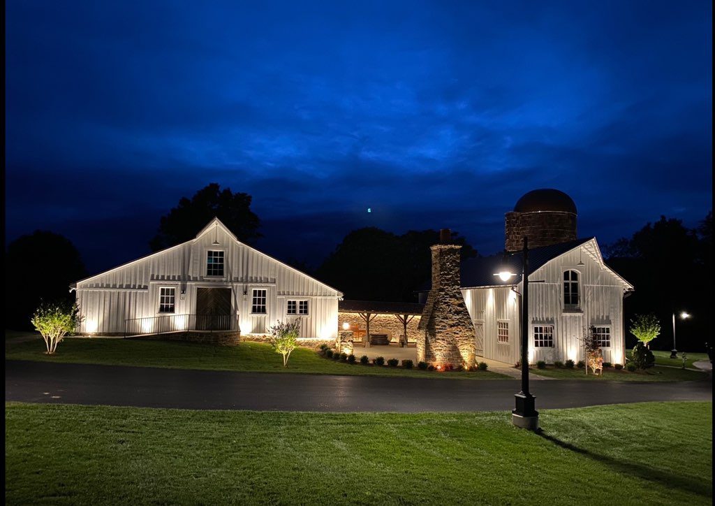 Barn on grass at night with lights