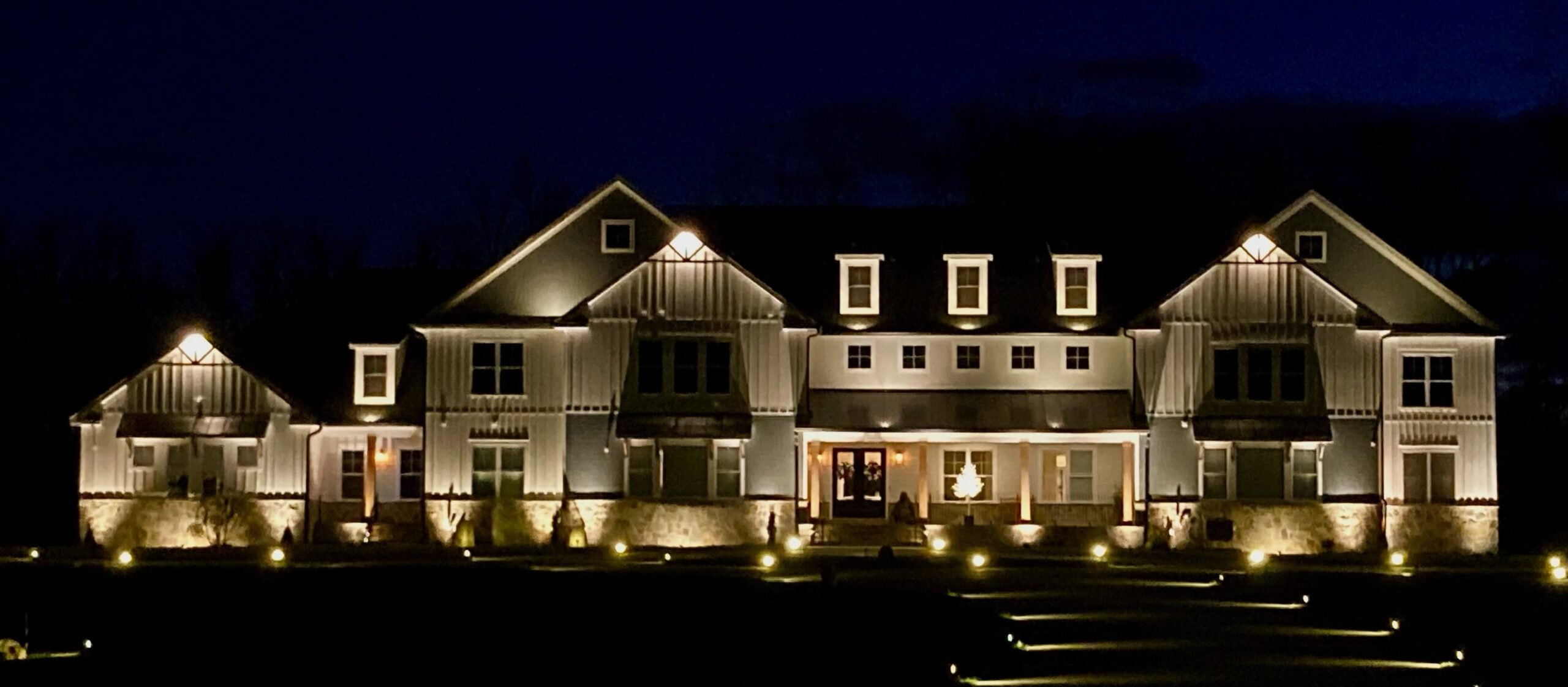 landscape lighting illuminating a large house at night