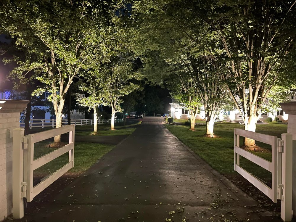 Close view with front gate open of illuminated estate at night